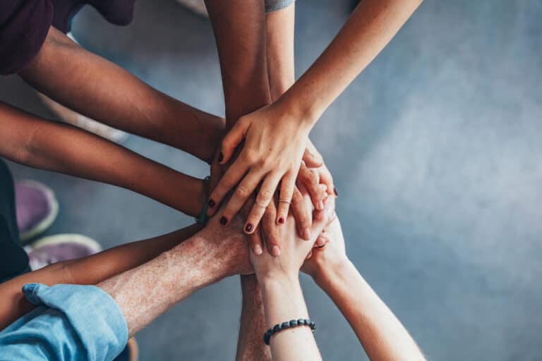 circle of people putting their hands together in partnership