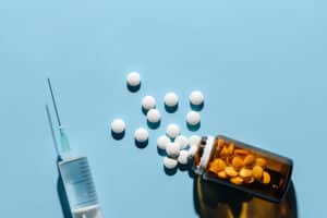 overflowing pill bottle and syringe