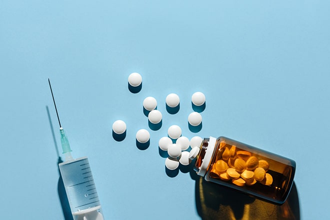 overflowing pill bottle and syringe