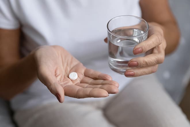 woman taking Suboxone prescription with a glass of water