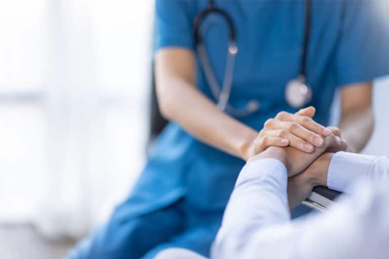 doctor holding a patient's hand in support